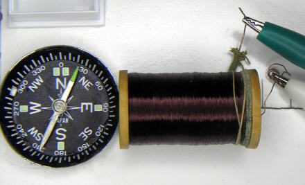 A coil of copper wire next to the compass, deflecting the needle slightly